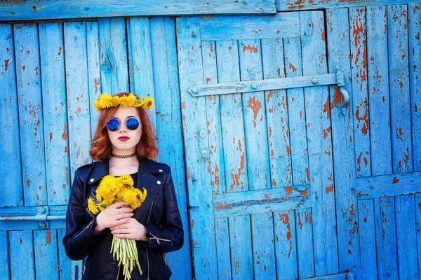 Girl in a black jacket and hat with a bouquet of dandelions — Stock Photo, Image
