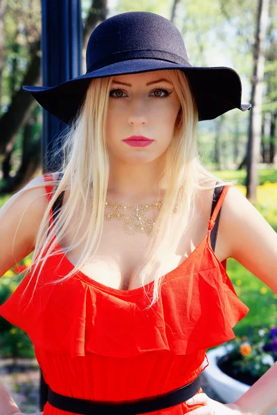 Menina elegante em um vestido vermelho andando no parque — Fotografia de Stock