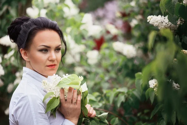 Beautiful brunette girl with lilac — Stock Photo, Image