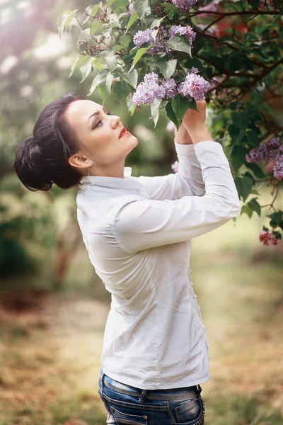 Beautiful brunette girl with lilac — Stock Photo, Image