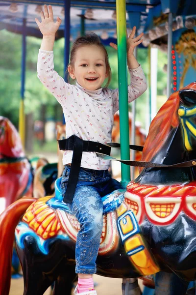 Little girl goes for a drive on carousel — Stock Photo, Image