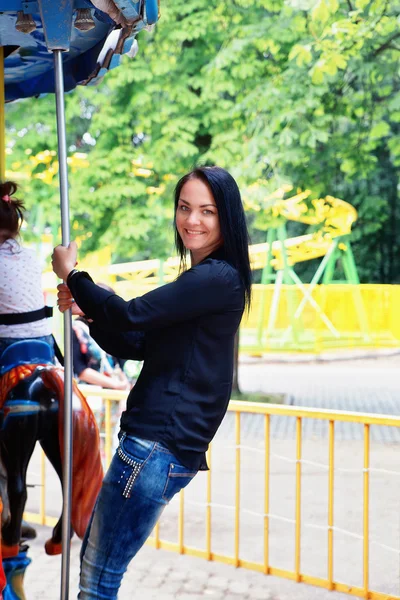 Carousel bir parkta kız rides — Stok fotoğraf