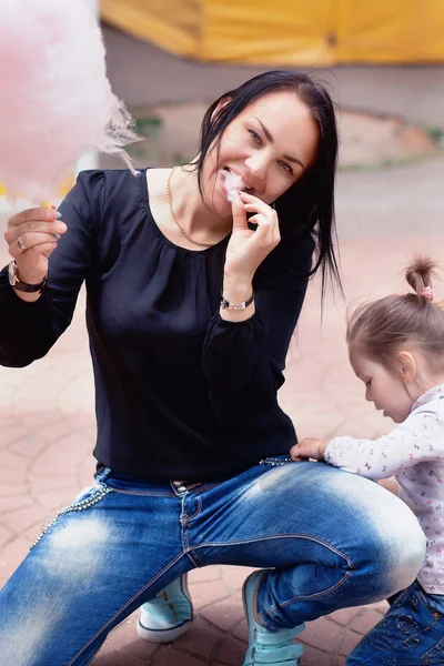 Mãe e filha no parque comendo algodão doce — Fotografia de Stock