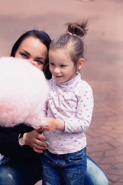 Mama i córka w parku jedzenia waty cukrowej — Zdjęcie stockowe