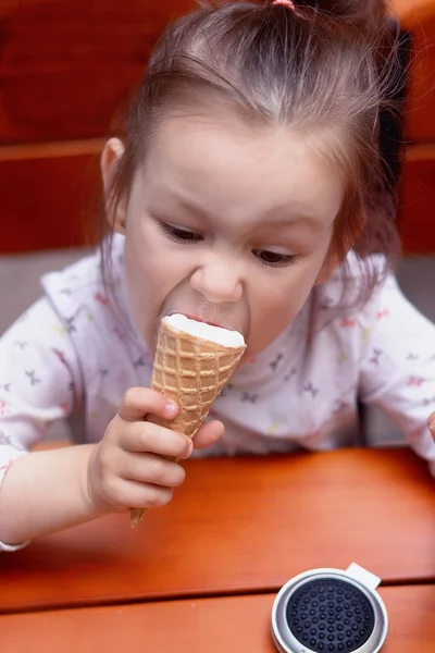 Little girl greedily eating ice cream — Stock Photo, Image