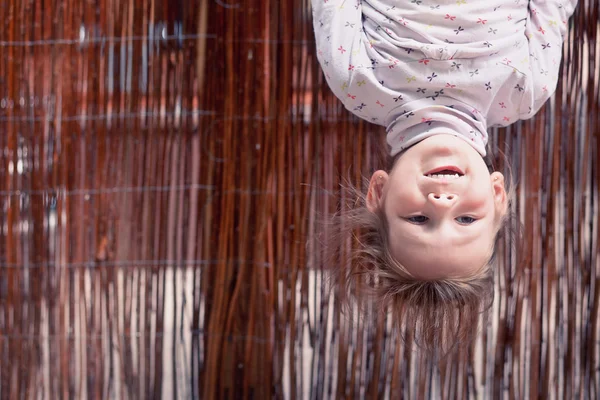 Little girl hanging upside down — Stock Photo, Image