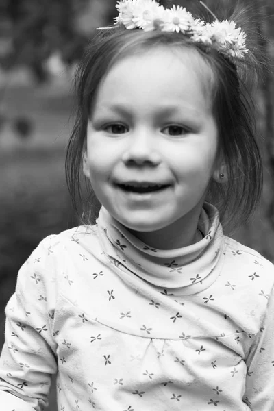 Petite fille avec une couronne de marguerites sur la tête. Noir et blanc — Photo