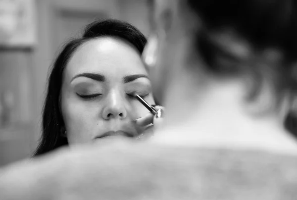 Professional makeup artist doing makeup. Black and white — Stock Photo, Image