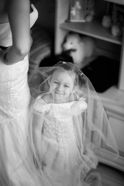 Menina pequena sob o vestido de noiva. Preto e branco — Fotografia de Stock