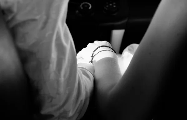 Mujer y hombre tomados de la mano en el coche. Blanco y negro — Foto de Stock