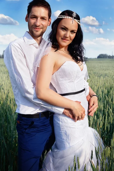 Bruid en bruidegom in een veld — Stockfoto