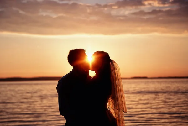 Novia y novio juntos en un fondo puesta de sol —  Fotos de Stock