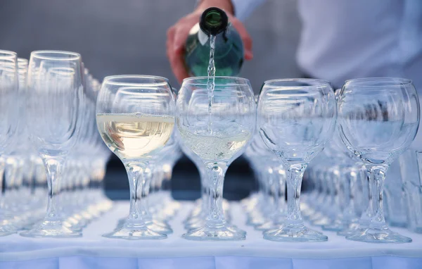 De ober giet wijn in een glas — Stockfoto
