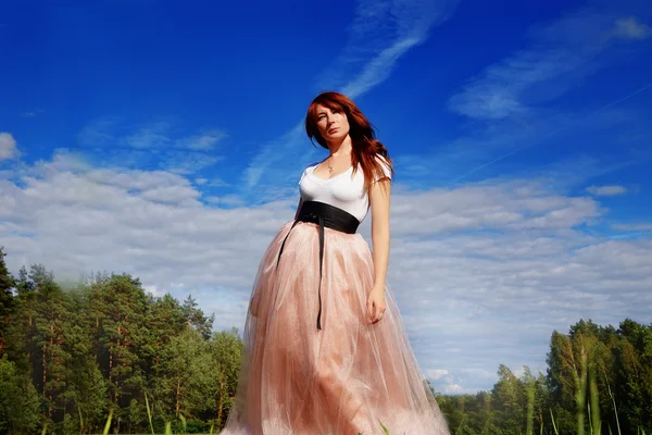 Красивая девушка в длинной розовой юбке — стоковое фото