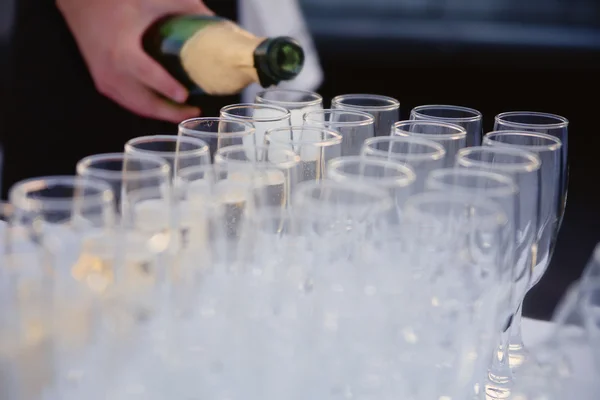 Kelner wlewa szampana do okularów. — Zdjęcie stockowe