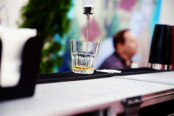 Viski bir cam içine dökme barmen — Stok fotoğraf