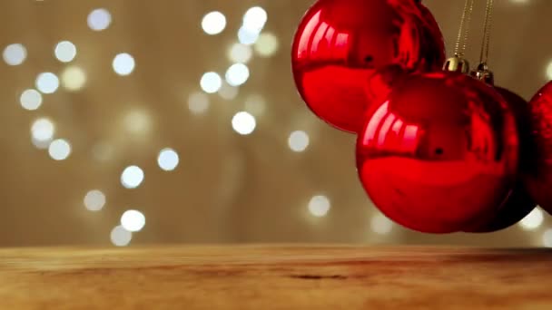 Palle rosse di Natale volteggiano su uno sfondo di ghirlande beige e scintillanti — Video Stock