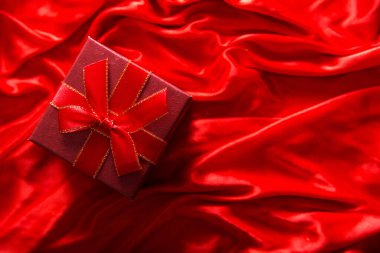 Kırmızı ipek arka planda kırmızı paketleme ile hediye