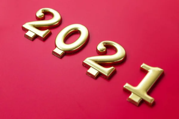 Happy New year 2021 celebration. Golden numbers 2021 as a symbol of the coming year on a red background. Horizontal photo