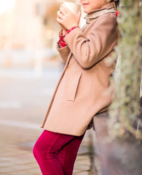 Ένα Κορίτσι Καφέ Παλτό Και Κόκκινο Παντελόνι Κρατά Ένα Ζεστό — Φωτογραφία Αρχείου