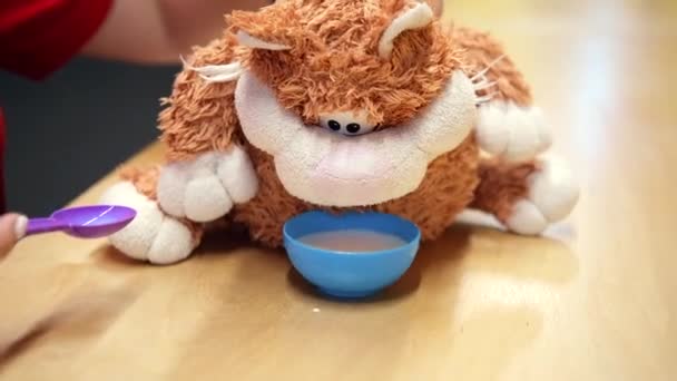 Игрушечная кошка пьет молоко из миски — стоковое видео