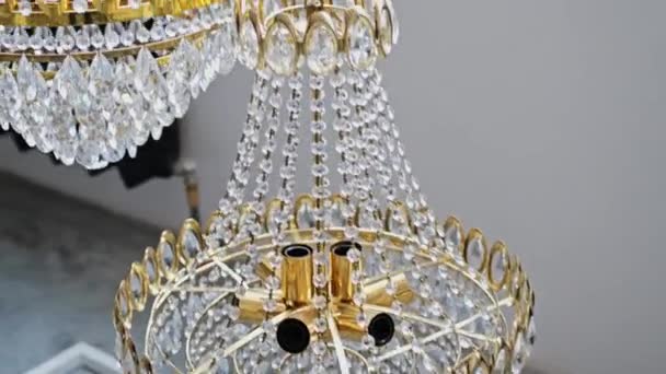 Kristallen kroonluchter versierd met gouden details in het interieur van de kamer — Stockvideo