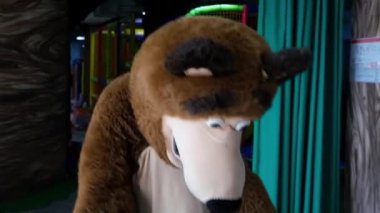 Boz ayının gerçek boyutlarda bir kuklası küçük bir çocukla oynayıp onu kollarının arasına alıyor. Yüksek kaliteli FullHD görüntüler. Minsk, Belarus - 5 Eylül 2021