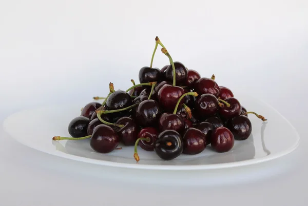 Fresh cherries on white plate — Stock Photo, Image