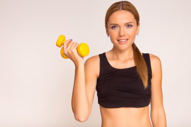 Sarı bir dumbbell tutan bir kadın. Uğraşan fitness. Stüdyo ph