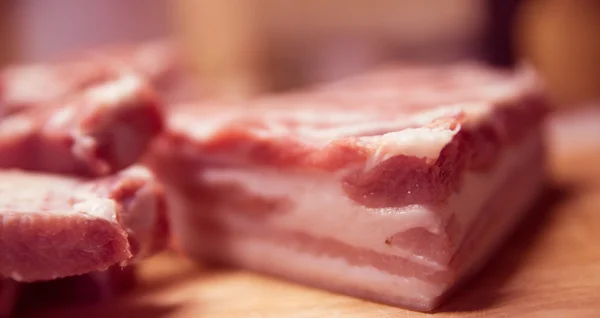 Varkensvlees belly slice op een houten plank — Stockfoto