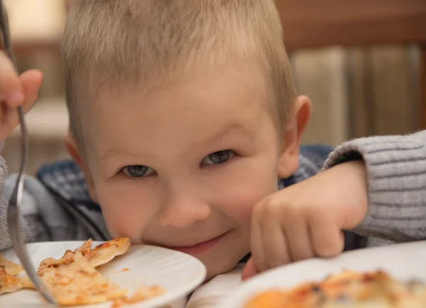 Ładny blond dziecko chłopczyk, śmiejąc się i jedzenie pizzy — Zdjęcie stockowe