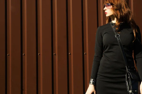 Cool vrouw dragen van een zonnebril in herfst jurk op bruin CHTERGRO — Stockfoto