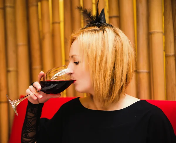 Hermosa bruja rubia joven en un café en un día de fiesta de Halloween — Foto de Stock