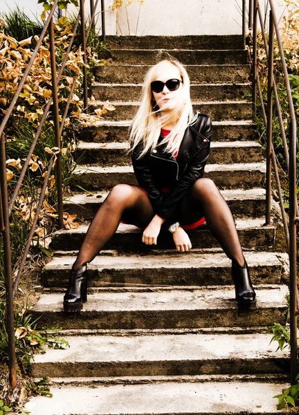 Schöne junge Frau in schwarzer Lederjacke und Sonnenbrille — Stockfoto