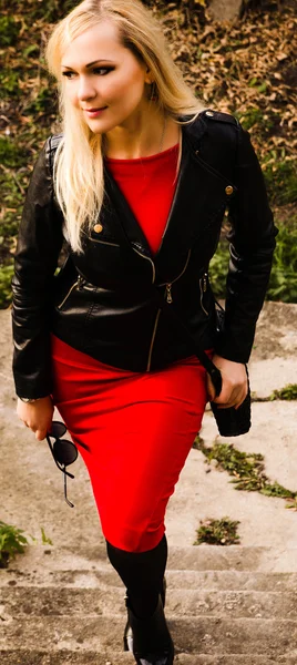 Mooie jonge vrouw in zwart lederen jas en zonnebril — Stockfoto