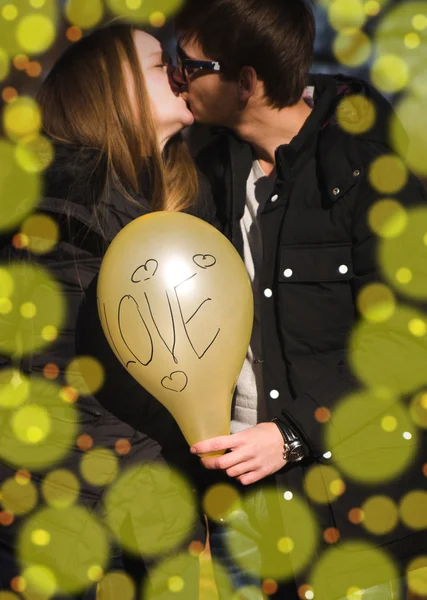 Sarı balon tutan genç mutlu çift — Stok fotoğraf
