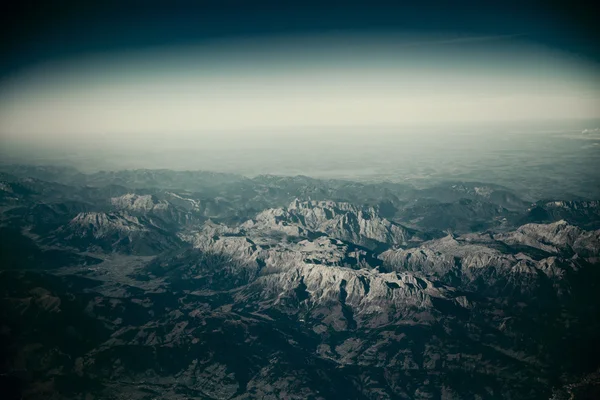 Blick von oben auf Berge mit Schnee und Wolken. — Stockfoto