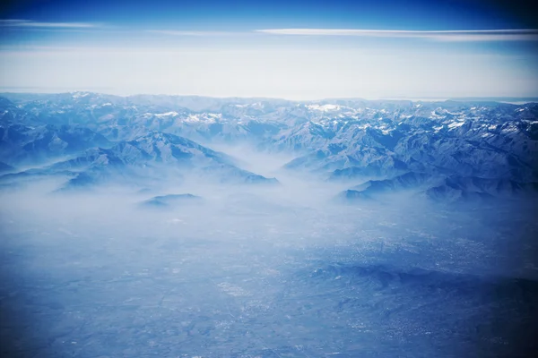 Blick von oben auf Berge mit Schnee und Wolken. — Stockfoto