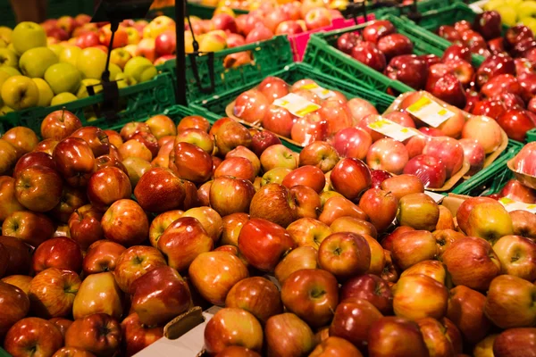 Bando de maçãs vermelhas e verdes em caixas no supermercado — Fotografia de Stock
