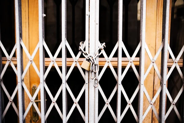 Двері залізних брусків замкнені ланцюгом і замком — стокове фото