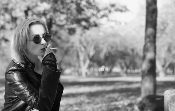 年轻女子在大街上抽烟。黑白照片 — 图库照片