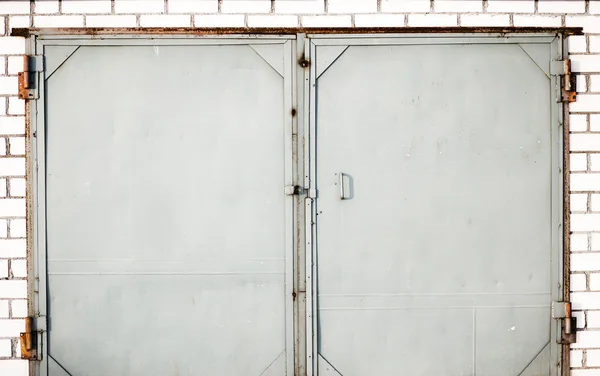 Una vieja puerta de hierro cerrada con pared de ladrillo — Foto de Stock