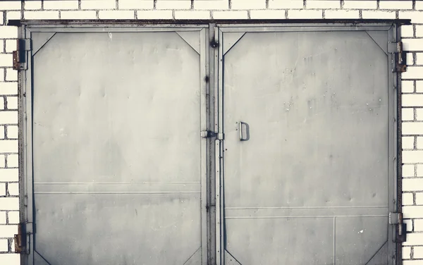 Una vecchia porta di ferro chiusa con muro di mattoni — Foto Stock