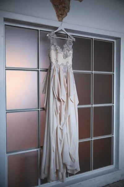 Esküvői ruha akasztás egy ablakban. — Stock Fotó