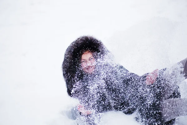 Schöne Winterfrau hat Spaß im Winterpark auf Schnee liegend — Stockfoto