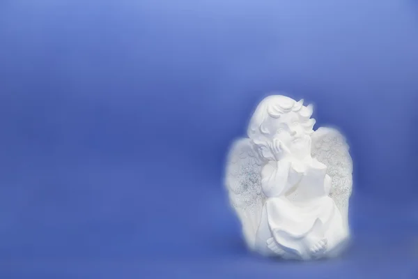 Cherub statuette isolated on blue — Stock Photo, Image