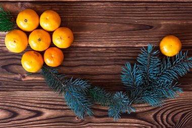 Noel ve yeni yıl mandalina yanındaki ahşap arka plan üzerinde koniler ile Noel ağacı dalları