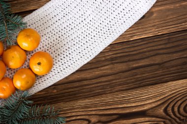 Noel ve yeni yıl mandalina renkli örgü kazak, koniler, ahşap arka plan üzerinde Noel ağacın yanındaki