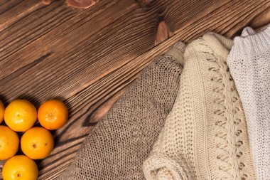 Noel ve yeni yıl mandalina renkli örgü kazak, koniler, ahşap arka plan üzerinde Noel ağacın yanındaki