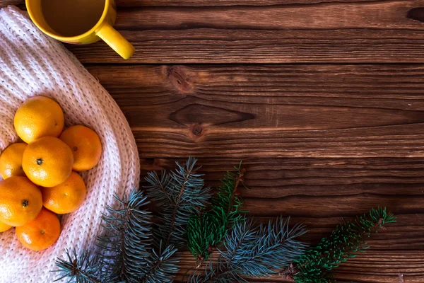 Noel ve yeni yıl mandalina renkli örgü kazak, koniler, ahşap arka plan üzerinde Noel ağacın yanındaki